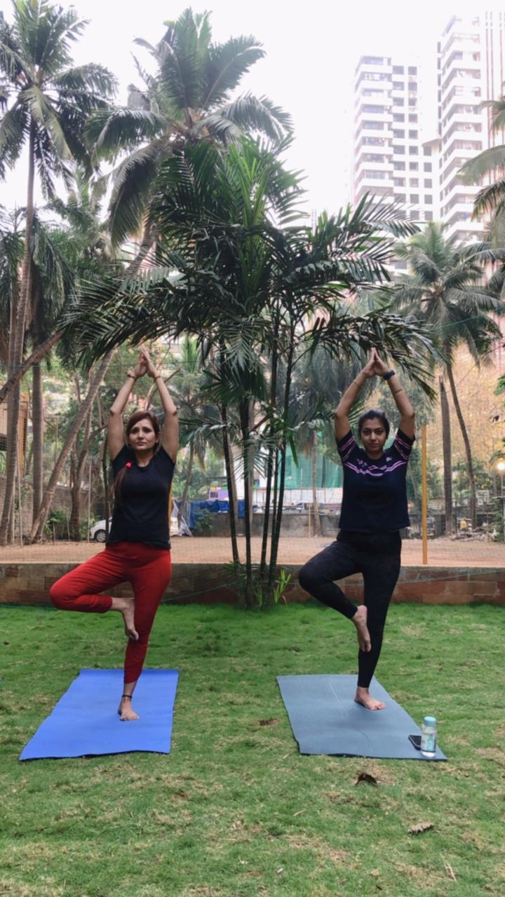 Guided tree pose balance on lawn with student